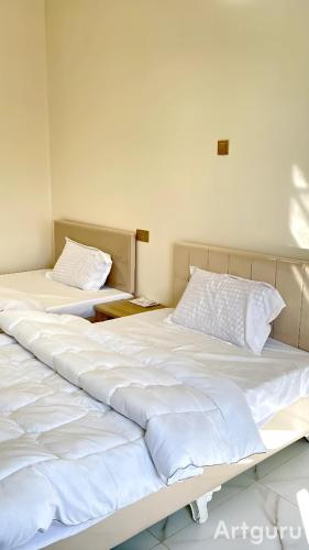 two beds sitting next to each other in a room at فندق وادي السحتن in Al Ambaḩ