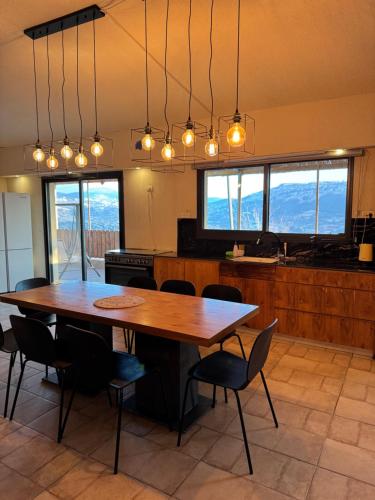 een keuken met een grote houten tafel en stoelen bij וילה סאן טורינו - Vila San Torino in Elqosh