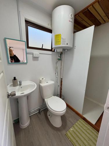 a bathroom with a toilet and a sink at Nomade Balmaceda in Balmaceda