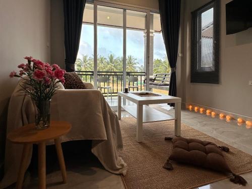 a living room with a vase of flowers on a table at Cozy Relax & Calm in Koh Phangan