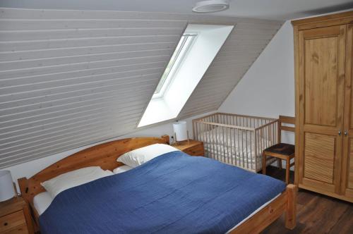 een slaapkamer met een blauw bed en een raam bij Schäferstübchen - Urlaub auf dem Bauernhof in Braunsberg