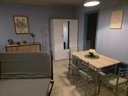 een eetkamer met een tafel en stoelen en een deur bij La Mésange Apprivoisée in Membre