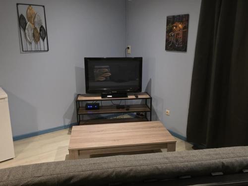 een woonkamer met een televisie en een salontafel bij La Mésange Apprivoisée in Membre