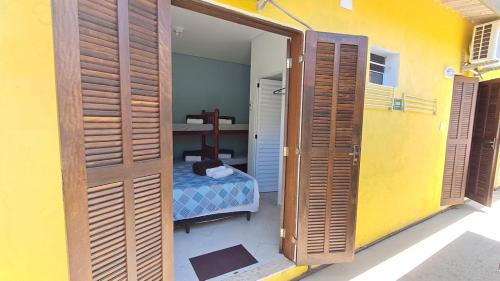 une porte menant à une chambre avec un lit dans l'établissement Suítes Cantinho do Sossego Ubatuba, à Ubatuba