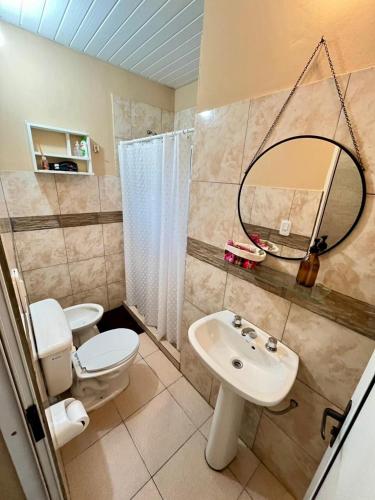 a bathroom with a toilet and a sink and a mirror at Casa Tekove in Clorinda