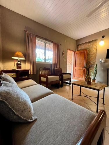 a bedroom with two beds and a living room at Casa Tekove in Clorinda