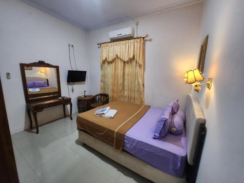 een slaapkamer met een bed en een televisie. bij Among Rogo Syariah in Yogyakarta