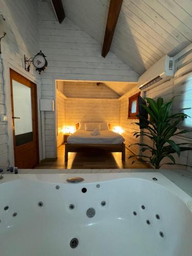 a room with a bed and a bath tub at לה בריזה - La Briza in Ma'alot Tarshiha