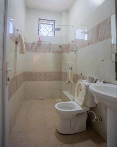 a bathroom with a toilet and a sink at SeyniKe 2BR Apartment - Nyali - AC, WiFi - Parking in Mombasa