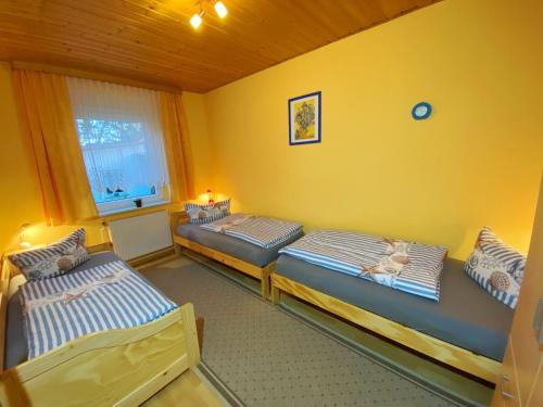 twee eenpersoonsbedden in een kamer met een raam bij Ferienwohnung Landmannsruh in Lubmin