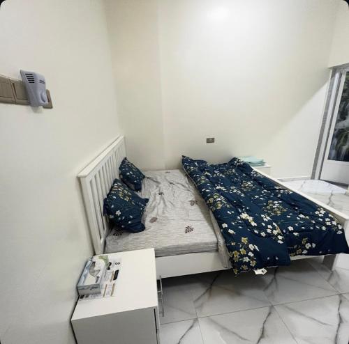 een klein bed in een kleine kamer met een tafel bij فندق وادي السحتن in Al Ambaḩ