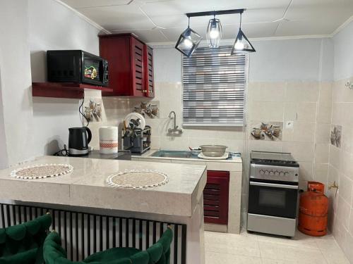 een keuken met rode kasten en een aanrecht bij Résidence Azur in Libreville