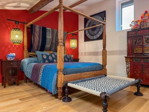 a bedroom with a canopy bed with a bench in it at Origines in Tautavel