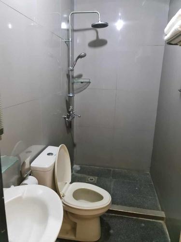 a bathroom with a toilet and a sink at Shine Hotel in Sampong