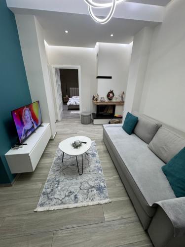 een woonkamer met een bank en een tafel bij RentRoom Ajan Apartment in Pogradec