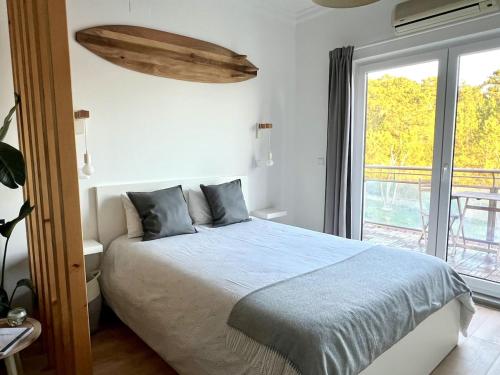 una camera da letto con un letto e una grande finestra di Seaven Ericeira Beach Studio a Ericeira