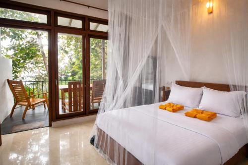 a bedroom with a bed and a balcony at Amado Homestay Ella in Ella