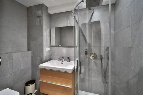 a bathroom with a shower with a sink and a shower at Aparthotel Žalý in Benecko