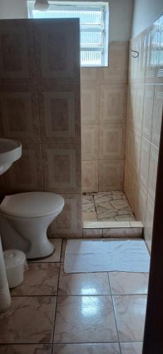 a bathroom with a shower with a toilet and a window at Pousada Rose Alves in Cachoeiras de Macacu