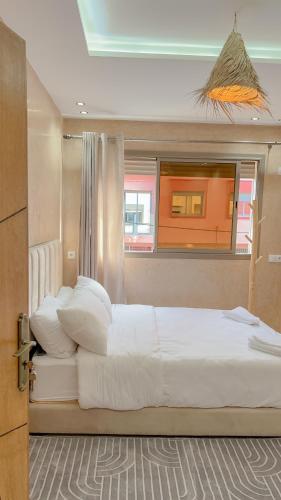 una camera da letto con un grande letto bianco con una finestra di Room a Imsouane