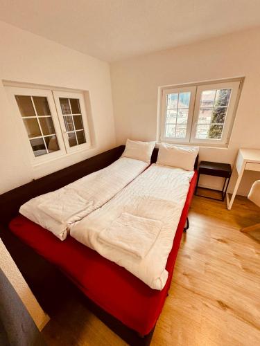 a large bed in a room with two windows at Gemütliches Wohnung für Familien und Gruppen in Küblis