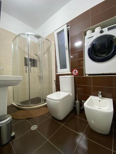 een badkamer met toilet en wasmachine bij Villa 35 in Tirana