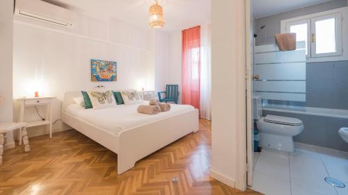 una camera da letto bianca con un letto e un bagno di Casa Paseo del Tajo Parking Incluido - Living Toledo a Toledo