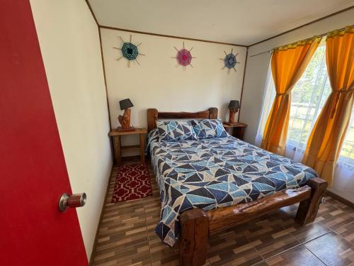 een slaapkamer met een bed en twee ramen met gordijnen bij Cabañas Granja Paraíso in Molina