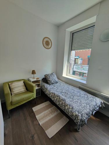een slaapkamer met een bed, een stoel en een raam bij AB Studio in Roubaix