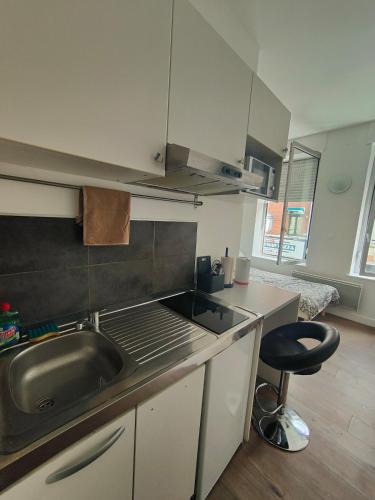 een keuken met een wastafel, een fornuis en een kruk bij AB Studio in Roubaix