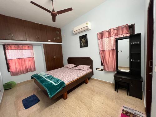 a bedroom with a bed and a dresser and a mirror at MUBSS Homestay in Tiruchirappalli