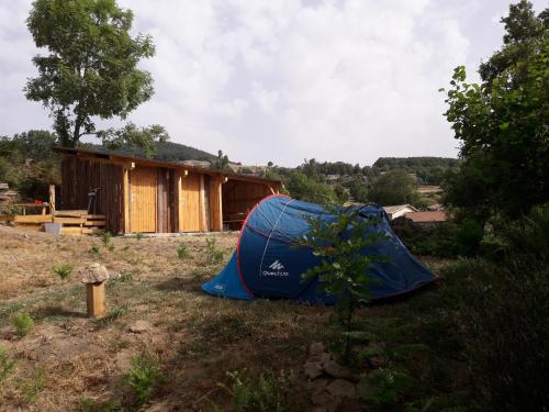 een tent in het gras voor een huis bij Camping à la Ferme de la Marette in Gluiras