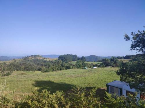 un emplacement de camping au milieu d'un champ herbeux dans l'établissement Camping à la Ferme de la Marette, à Gluiras