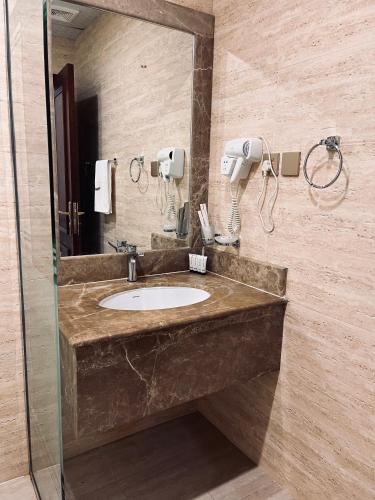 a bathroom with a sink and a mirror at Mabeet Al-Khobar in Al Khobar