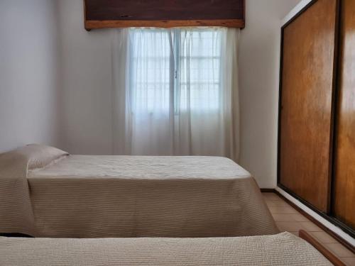 a bedroom with a bed and a window at Casa Q a 5km del centro de Villa Carlos Paz in Villa Santa Cruz del Lago