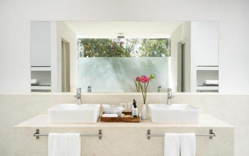 een badkamer met twee wastafels en een grote spiegel bij The Forest in Siem Reap