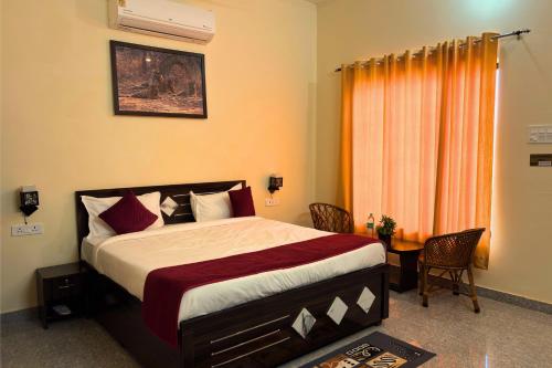 ein Schlafzimmer mit einem Bett und einem Tisch und einem Fenster in der Unterkunft Ranthambore Village Serai in Khilchīpur