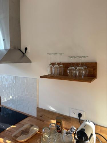 una cucina con un bancone con bicchieri su uno scaffale di Résidence ARTHUS Ménalippe a Pierrefonds