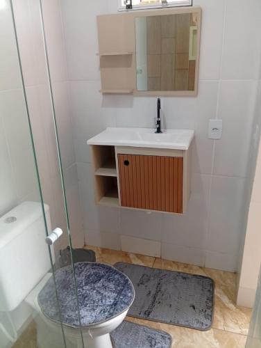 a bathroom with a toilet and a sink and a mirror at Cozy house in Matariz Beach in Angra dos Reis