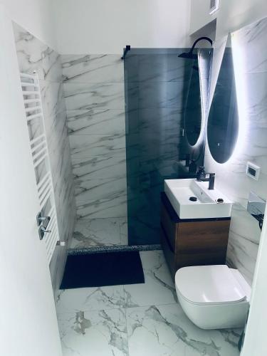 a bathroom with a white toilet and a sink at Garsoniera lux in Craiova