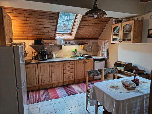 een keuken met een tafel en een keuken met een koelkast bij Chata Kubko in Bobrovník