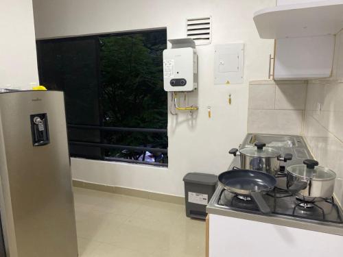 a kitchen with a stove and a window at Apartahotel Provenza in Medellín