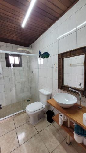 a bathroom with a toilet and a sink at Pousada Uluwatu, Praia do Rosa in Praia do Rosa