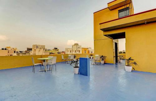 a balcony with tables and chairs on a building at Super Hotel O Royal Suites in Bengaluru
