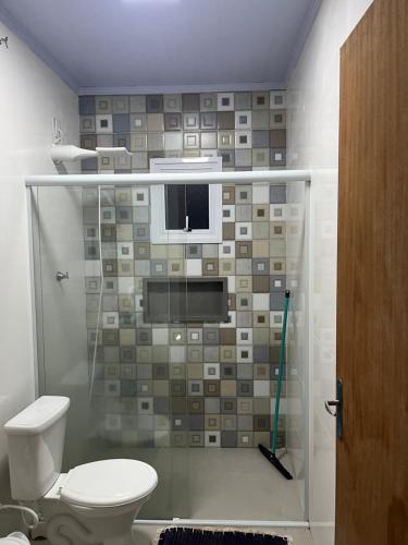 a bathroom with a shower with a toilet at Geminado Praia pérola in Passo De Torres