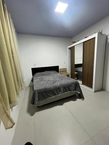 a bedroom with a bed and a cabinet in it at Geminado Praia pérola in Passo De Torres