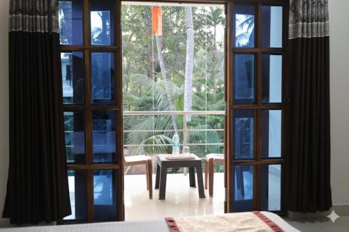 een open deur naar een kamer met een tafel erbuiten bij Konkan Paradise-Siddhivinayak,Devbag Beach Resort in Malvan