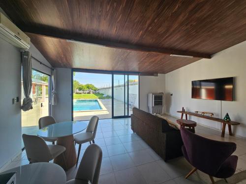 een woonkamer met een tafel en stoelen en een zwembad bij Chácara Urbana in Juazeiro