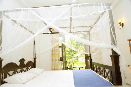 a bedroom with a bed and a window at Villa Arcadia in Tangalle