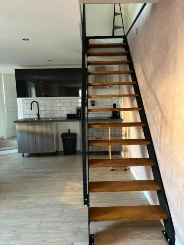 een houten trap in een keuken naast een keuken bij Maison f2 avec cour privative in Montceau-les-Mines